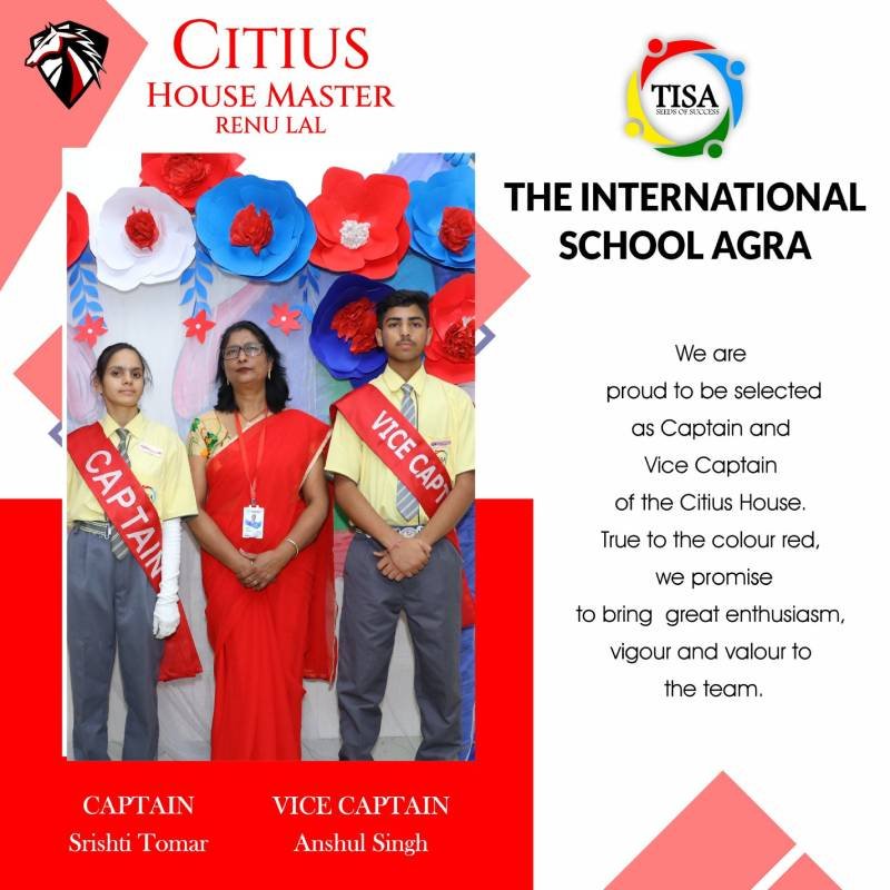 Photo of srishti tomar (captain) and anshul singh (vice captain) of citius house at the international school agra, standing on either side of house master renu lal. All are posed in front of a decorative backdrop with red, white, and blue paper flowers. The students wear yellow shirts, grey trousers, and red sashes labeled "captain" and "vice captain". Renu lal is dressed in a red saree, matching the house color. Text on the right expresses their pride in representing citius house and their commitment to bringing enthusiasm, vigor, and valor to the team. The school logo is displayed at the top.