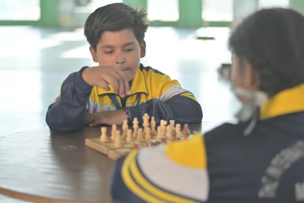 Two students from the best school in agra, tisa, engaged in a focused chess match during a school activity.
